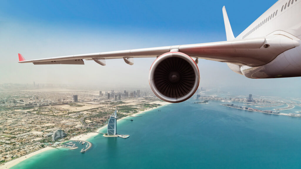 Commercial jet plane flying above Dubai city
